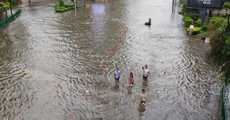ব্যাংককের রাচাথেওয়ি জেলায় বন্যার পানিতে ডুবে থাকা সড়ক পার হচ্ছেন মানুষ